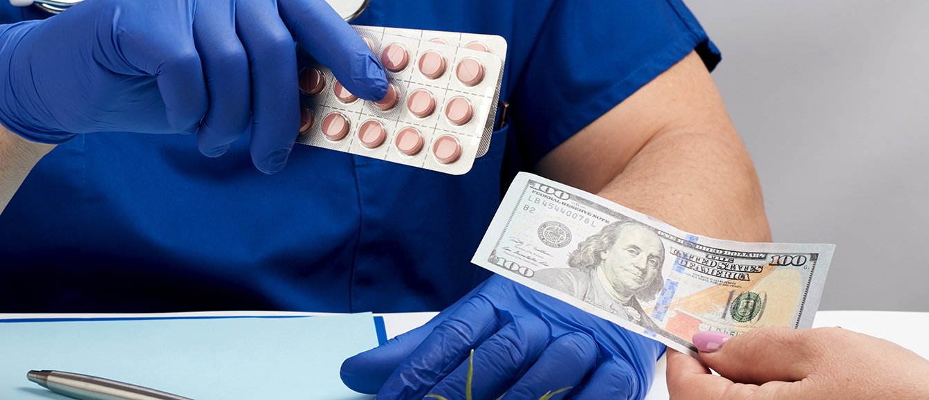 Léky a peníze v rukou.